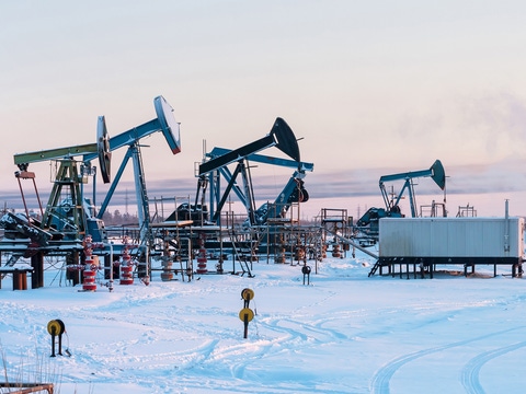 Oil Field. Winter industrial landscape with an oil pump and torch in the background. Oil Field. Winter industrial landscape with an oil pump and torch in the background.